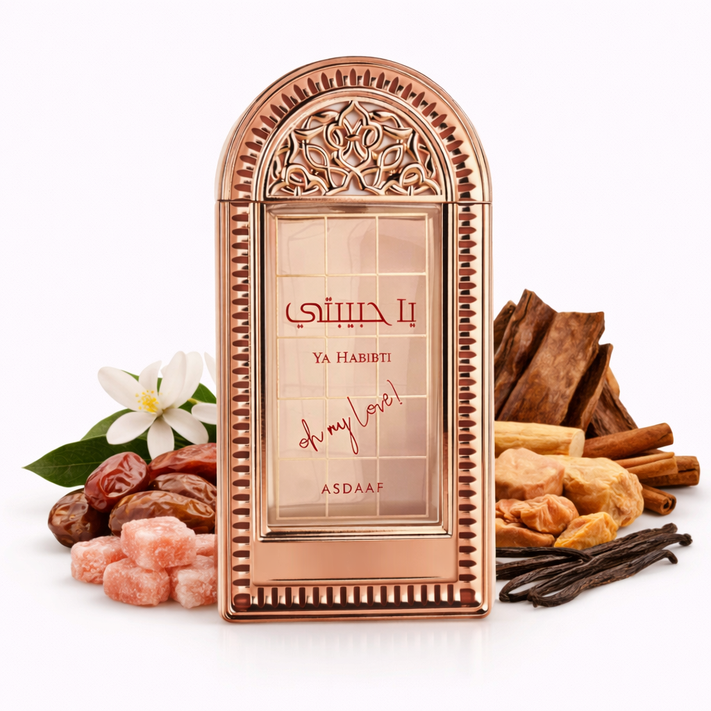 Un flacone di profumo color oro rosa per "Ya Habibi – Asdaaf" dal design orientale ad arco su sfondo bianco. Circondato da datteri, cristalli di zucchero rosa, fiori bianchi, baccelli di vaniglia, bastoncini di cannella e pezzi di legno, che sottolineano la composizione dolce, cremosa e speziata della fragranza.
